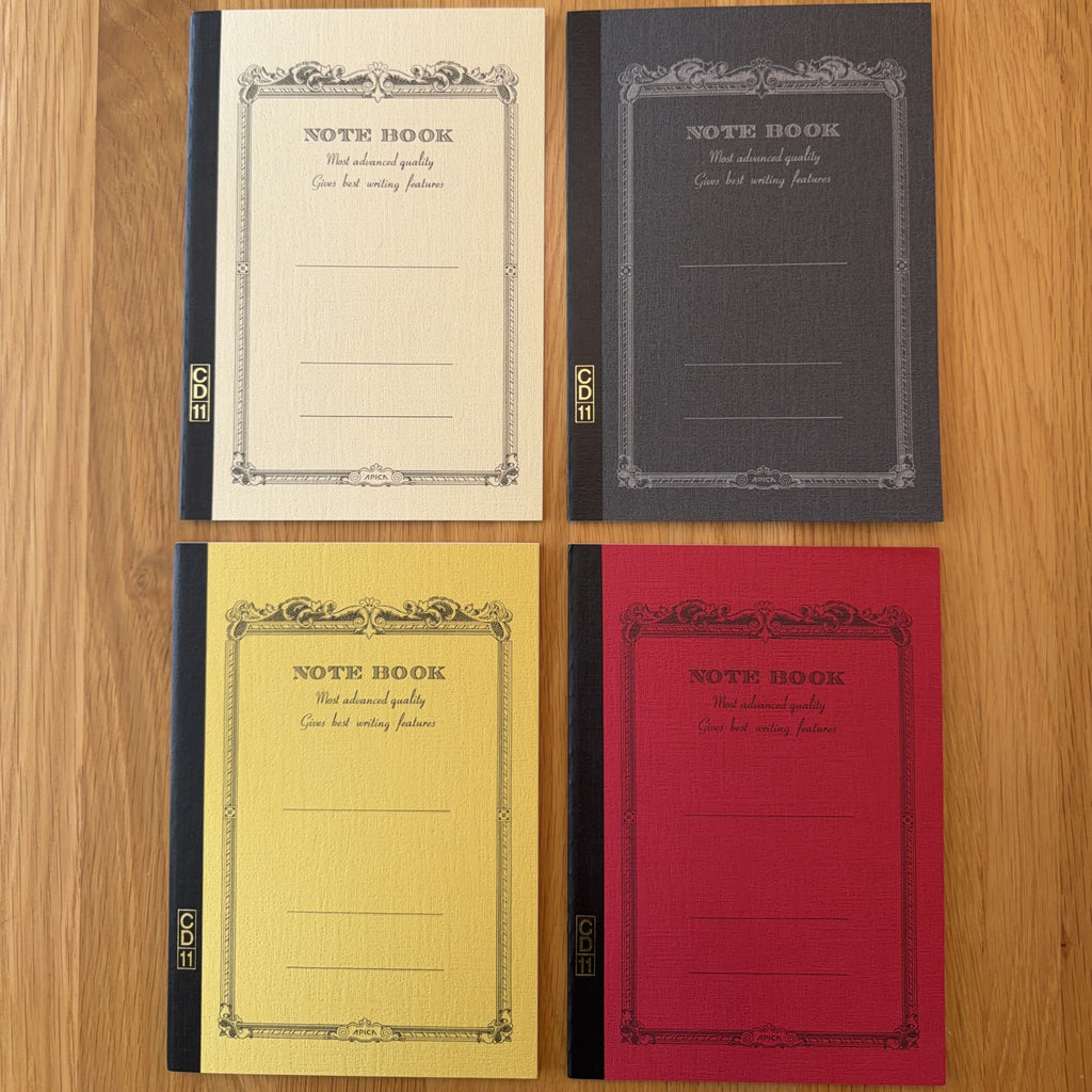 Four Apica CD Notebook A5 colors (Yellow, Black, Mustard, and Red) shown together