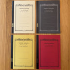 Four Apica CD Notebook A5 colors (Yellow, Black, Mustard, and Red) shown together
