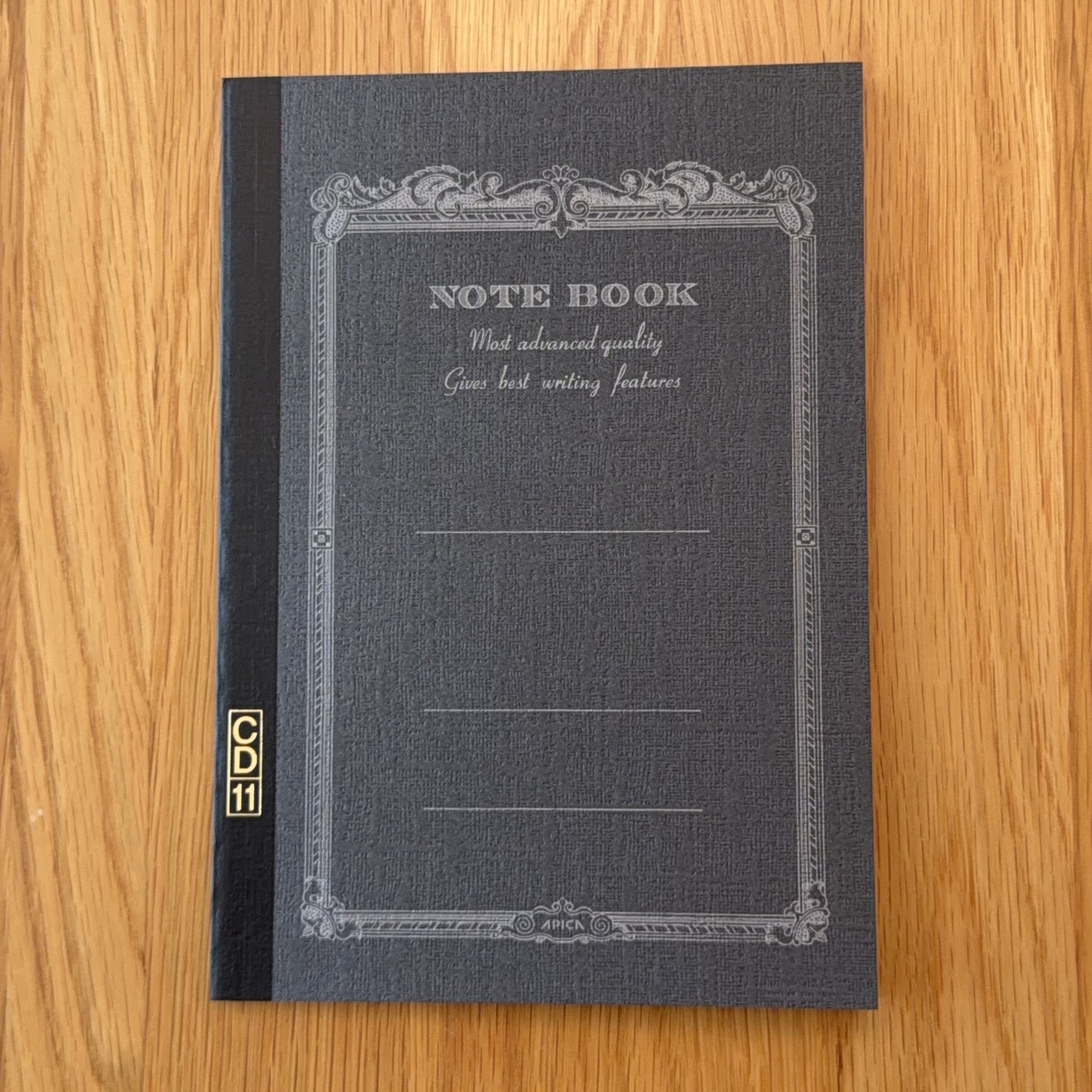 Apica CD Notebook A5 in Black, shown flat on a wooden surface