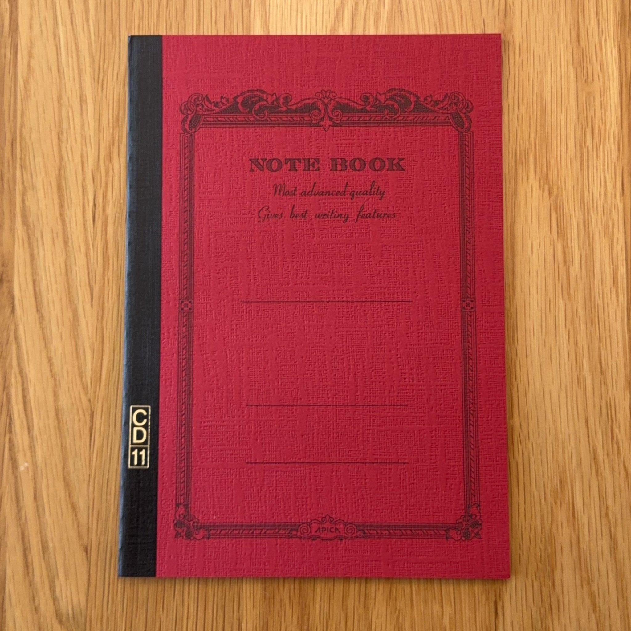 Apica CD Notebook A5 in Red, shown flat on a wooden surface