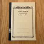 Apica CD Notebook A5 in Yellow, shown flat on a wooden surface