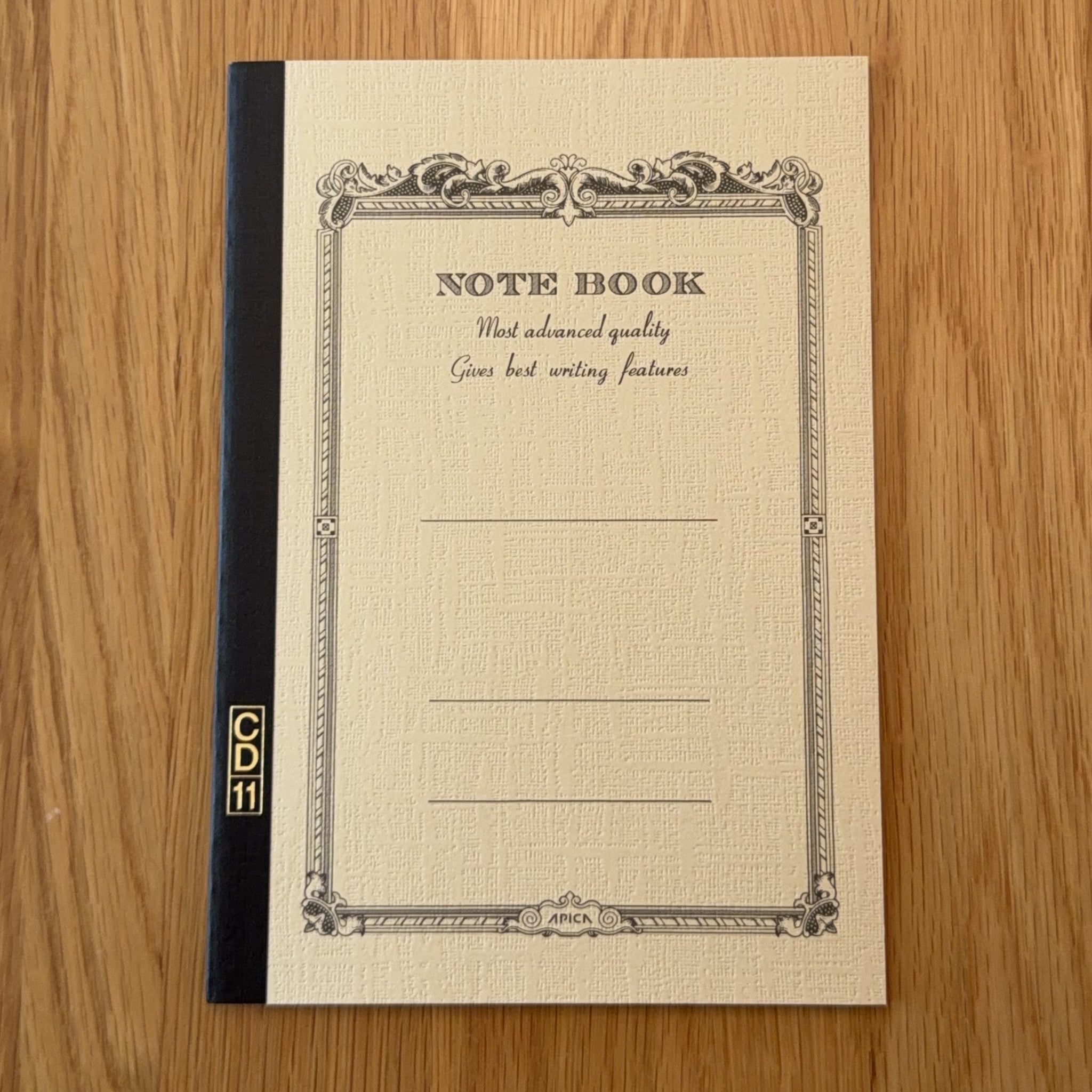 Apica CD Notebook A5 in Yellow, shown flat on a wooden surface
