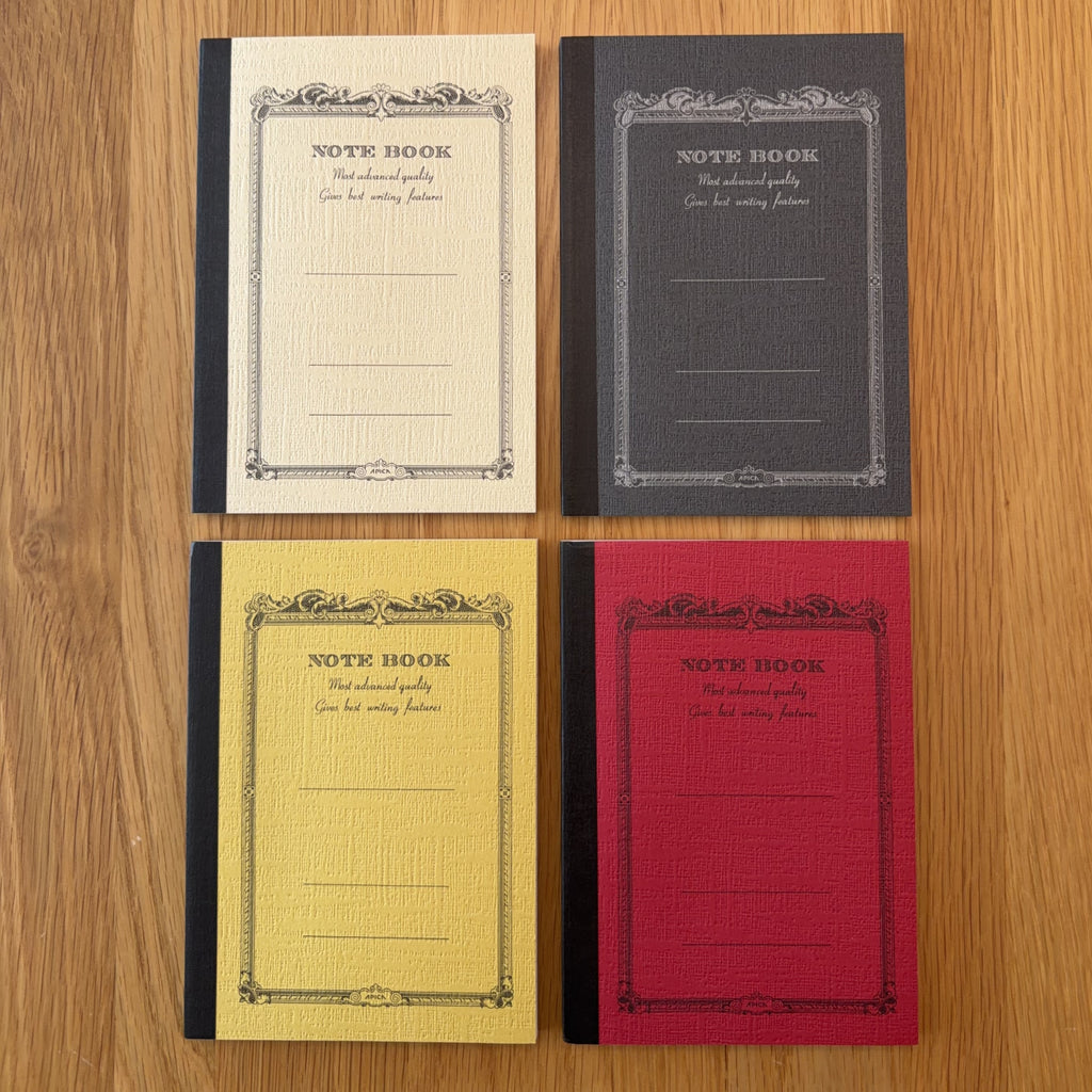 Four Apica CD Notebook A6 colors (Yellow, Black, Mustard, and Red) shown together