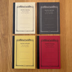 Four Apica CD Notebook A6 colors (Yellow, Black, Mustard, and Red) shown together