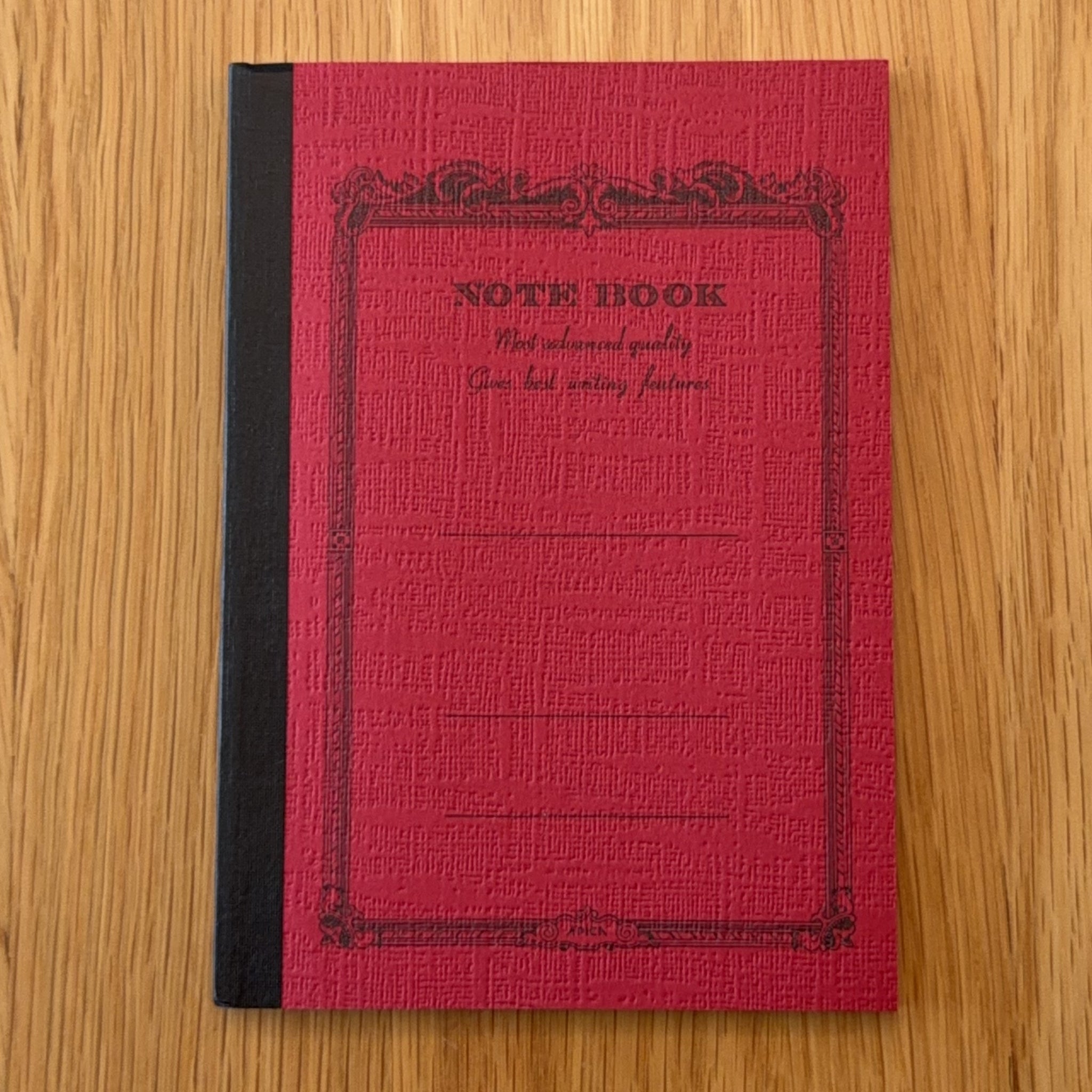 Apica CD Notebook A6 in Red, shown flat on a wooden surface