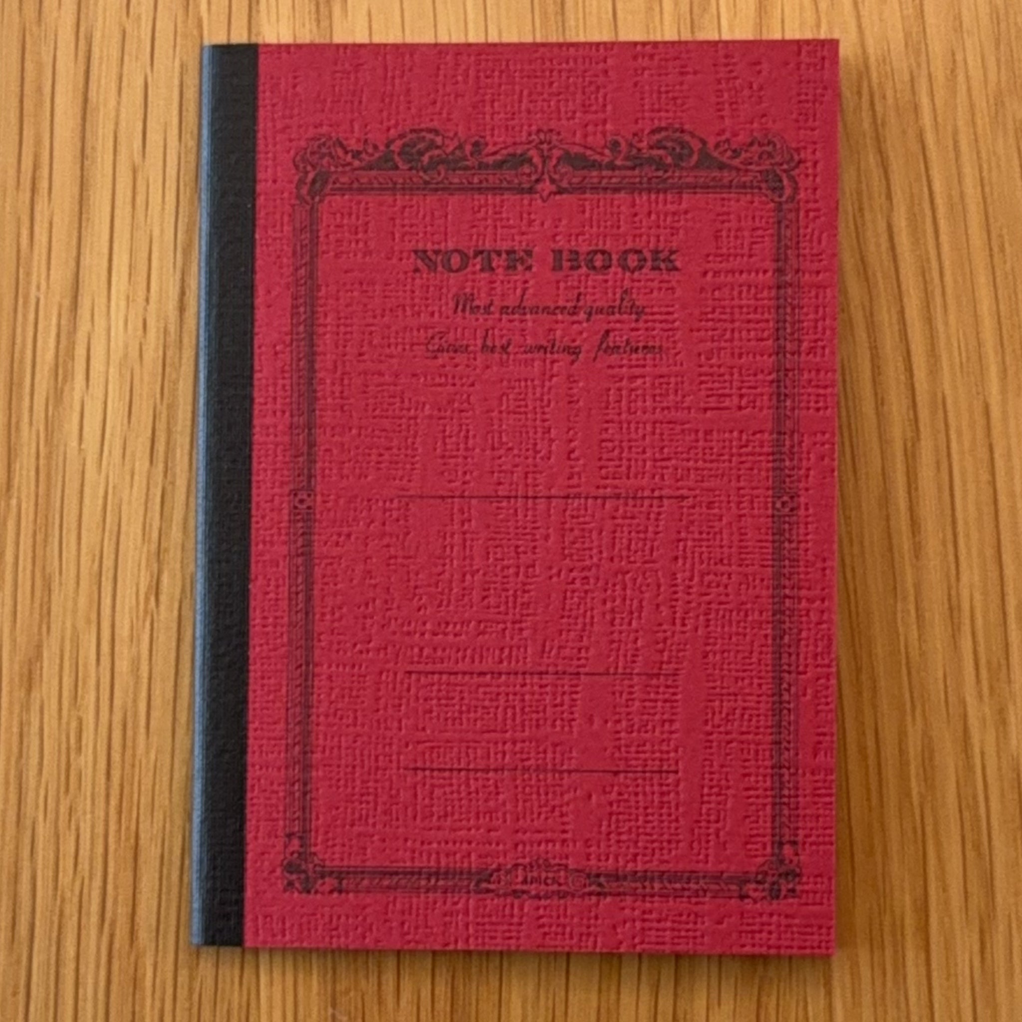 Apica CD Notebook A7 in Red, shown flat on a wooden surface