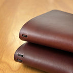 Two Journey leather covers stacked showing one spine cord versus two spine cords for holding notebook inserts