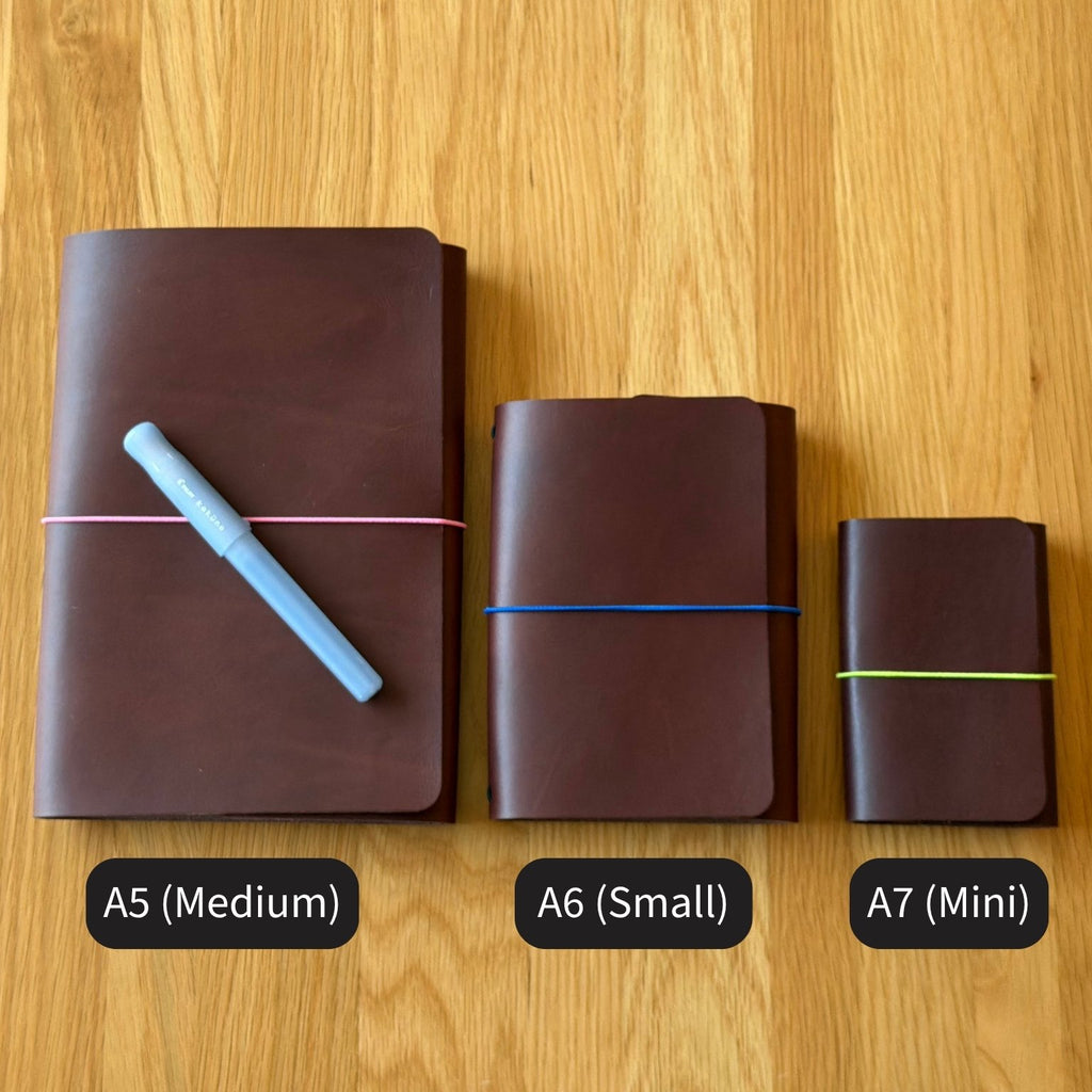 Three Floramoon Journey leather covers in Tobacco side by side comparing sizes - A5 Medium, A6 Small, and A7 Mini - with a Kakuno Madoromi in Periwinkle