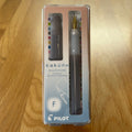 Pilot Kakuno Madoromi Fountain Pen in Gray, shown in its original packaging on a wooden surface, with the translucent barrel and gold nib visible through the case