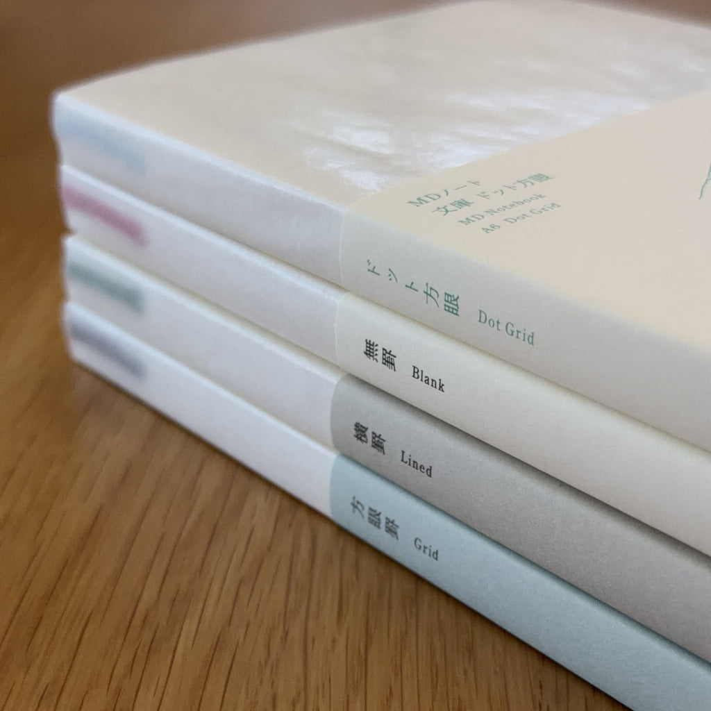 Stack of four Midori MD Notebook A5 ruling types — Blank, Lined, Grid, and Dot Grid