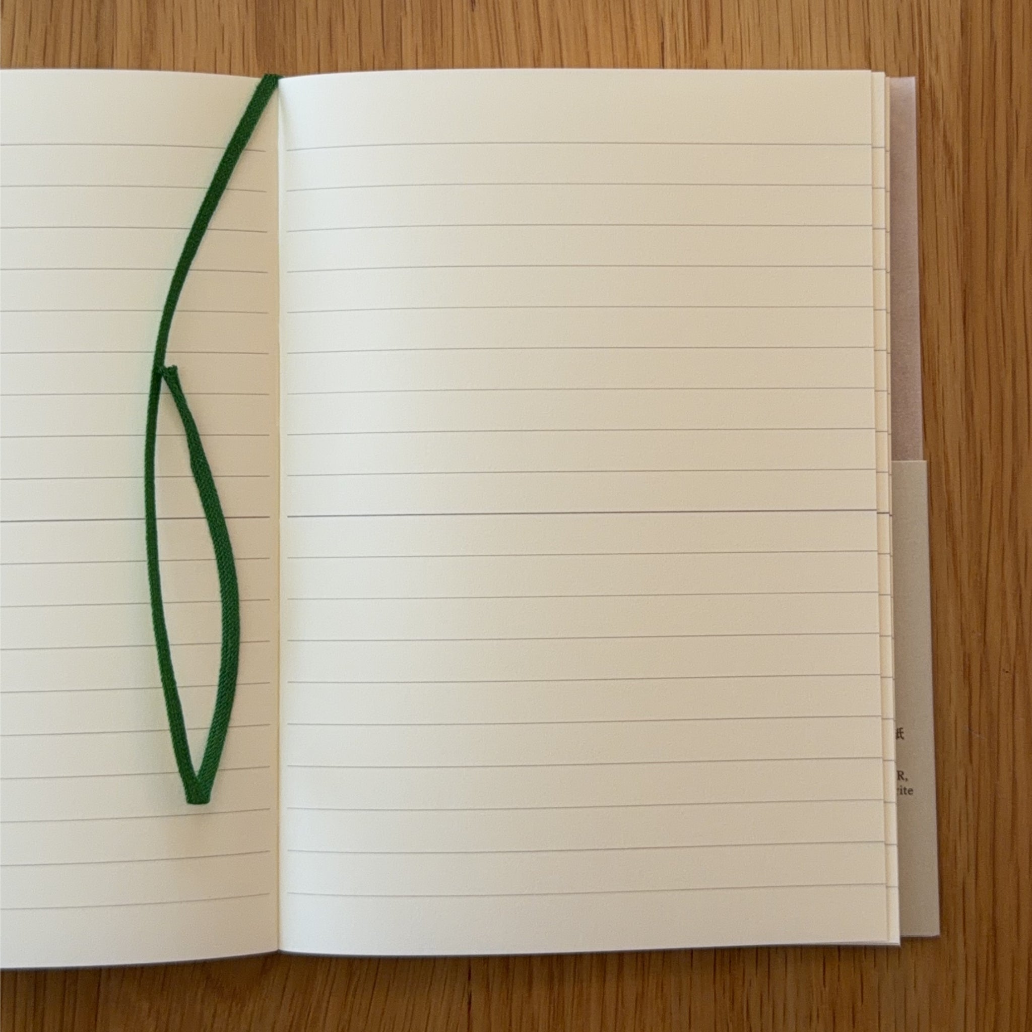 Midori MD Notebook A5 open to show the lined MD Paper and its bookmark string