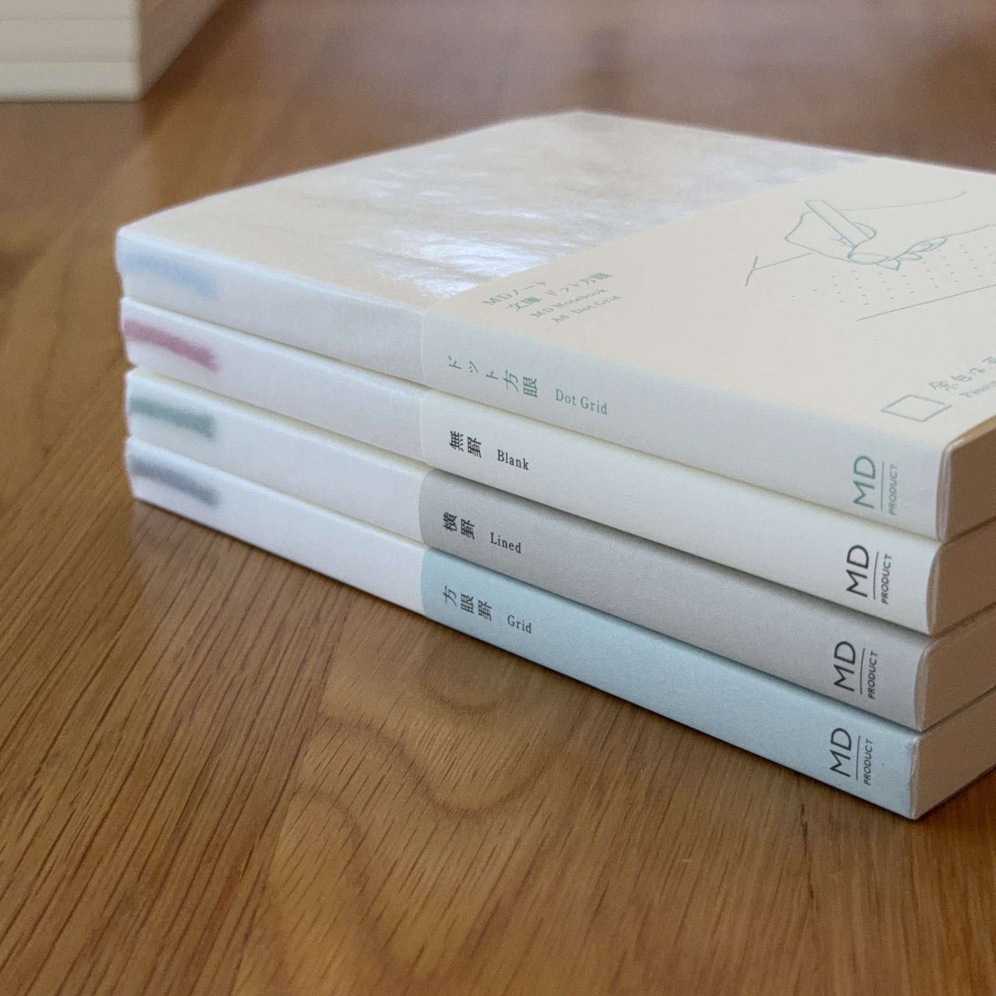 Stack of four Midori MD Notebook A6 ruling types — Blank, Lined, Grid, and Dot Grid