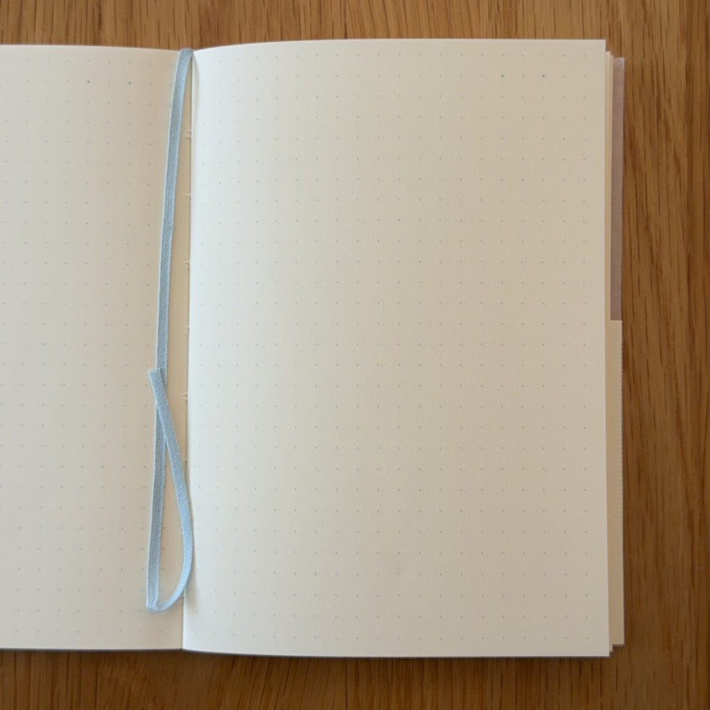 Midori MD Notebook A6 open to show the dot grid MD Paper and its bookmark string