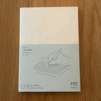 Midori MD Notebook A6 with glassine paper cover printed with a Grid ruling label and illustration