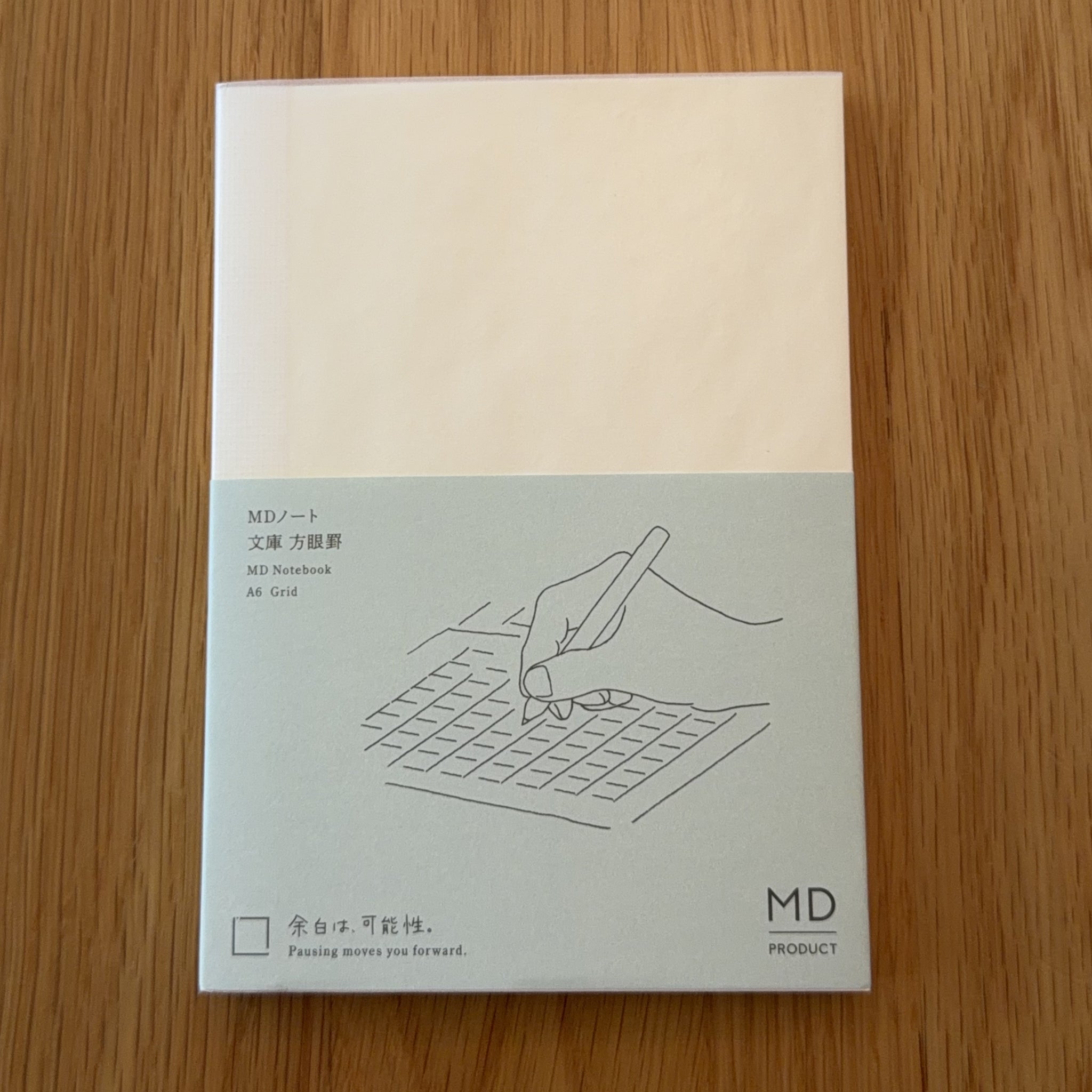 Midori MD Notebook A6 with glassine paper cover printed with a Grid ruling label and illustration
