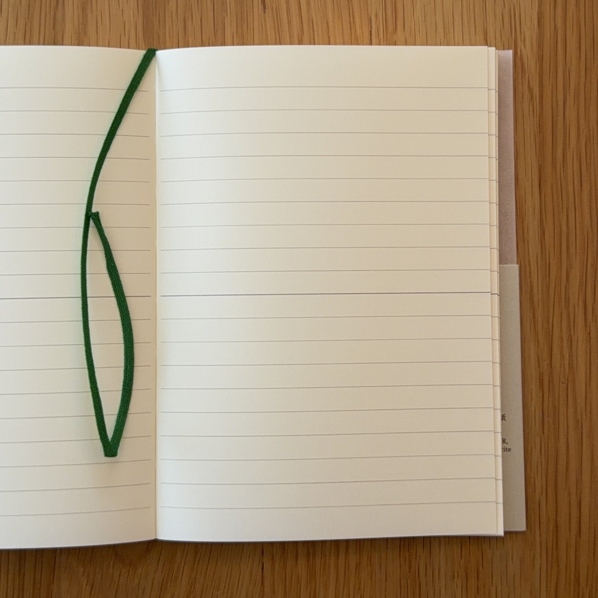 Midori MD Notebook A6 open to show the lined MD Paper and its bookmark string