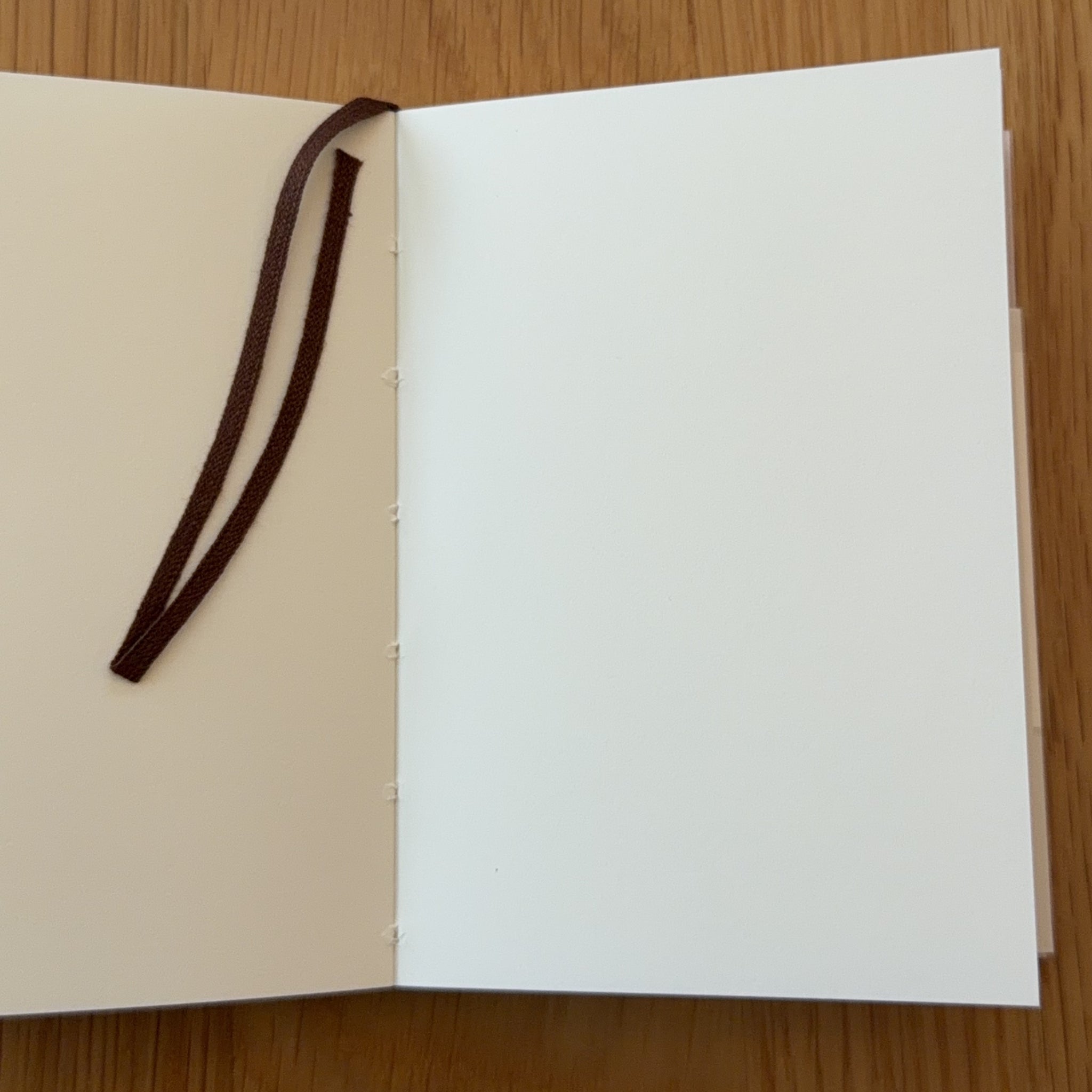 Midori MD Notebook A7 open to show the blank MD Paper and its bookmark string