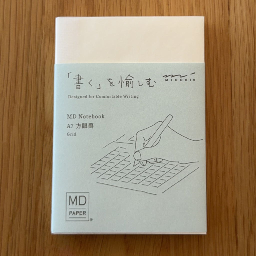 Midori MD Notebook A7 with glassine paper cover printed with a Grid ruling label and illustration