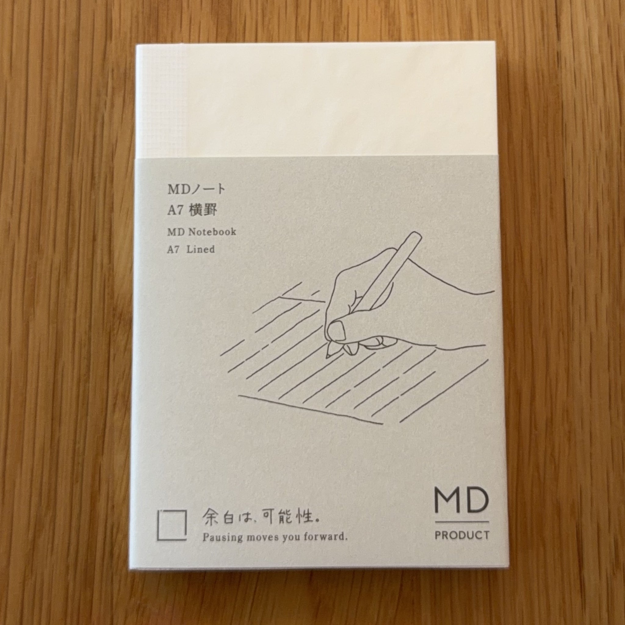 Midori MD Notebook A7 with glassine paper cover printed with a Lined ruling label and illustration